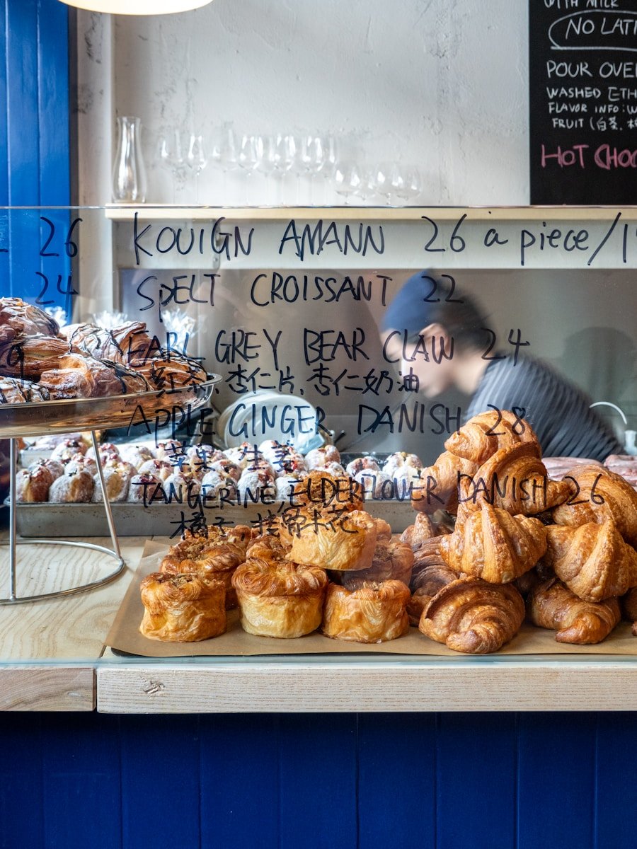 A man behind a counter filled with pastries